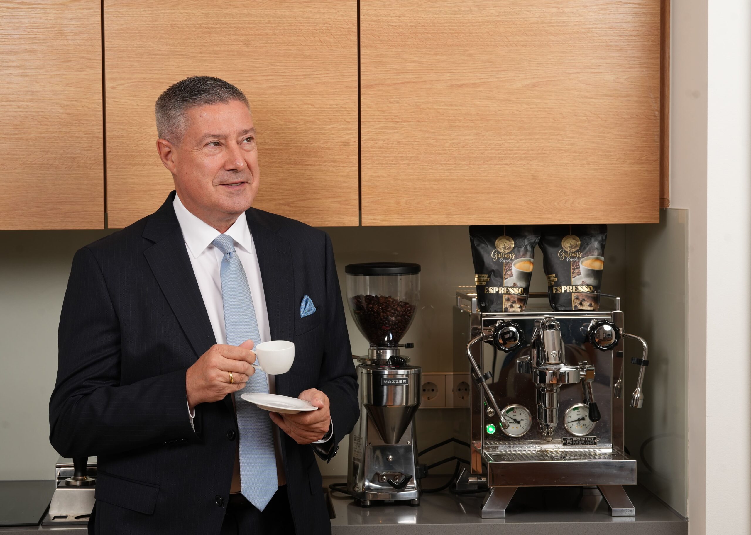 Joachim Llambi bei der Kaffeepause – stilvoller Genuss im Business-Alltag Joachim Llambi im Business-Outfit mit Espresso-Tasse vor einer Siebträgermaschine im Büro